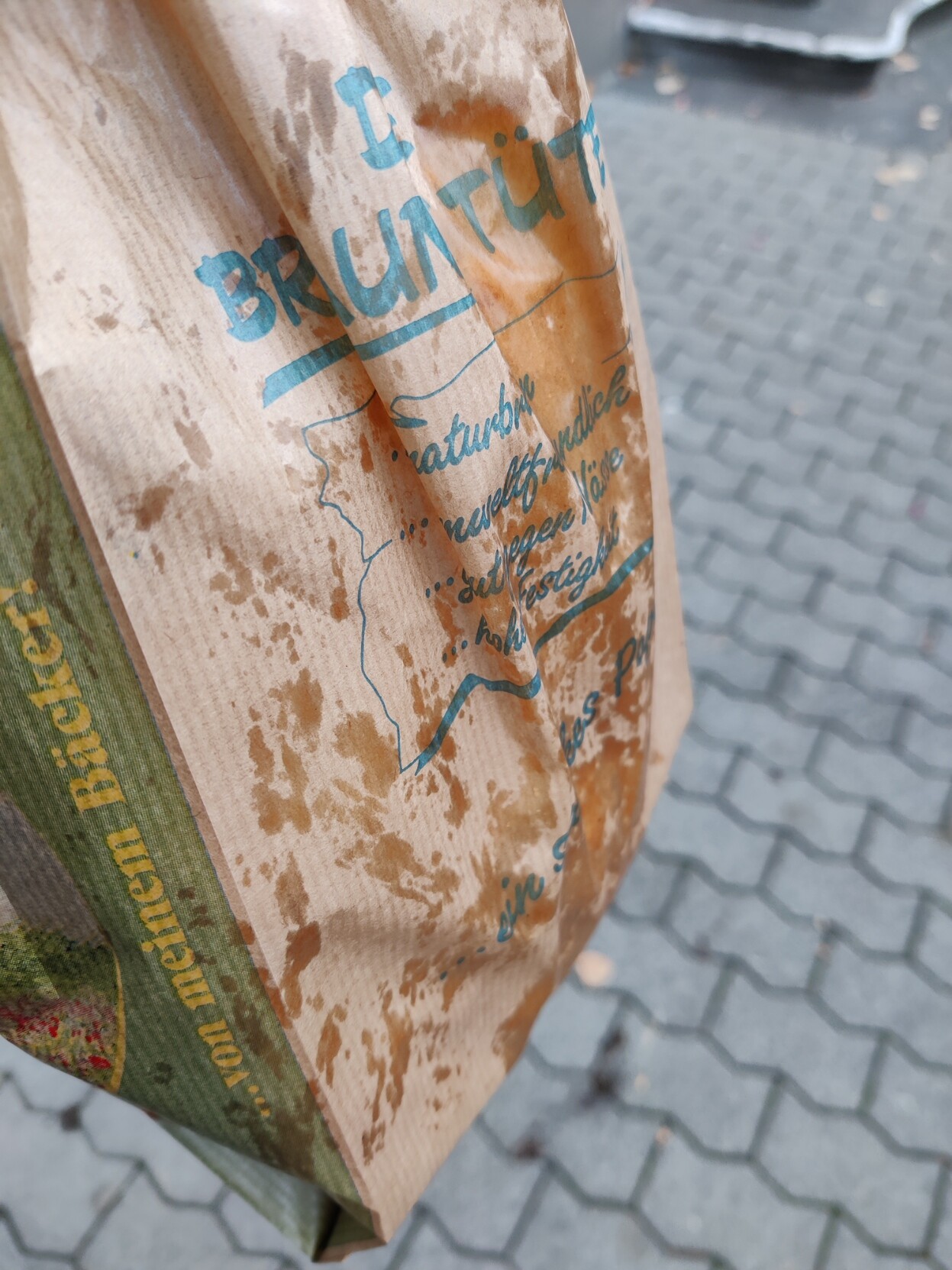 A brown paper bag with large grease stains all over it