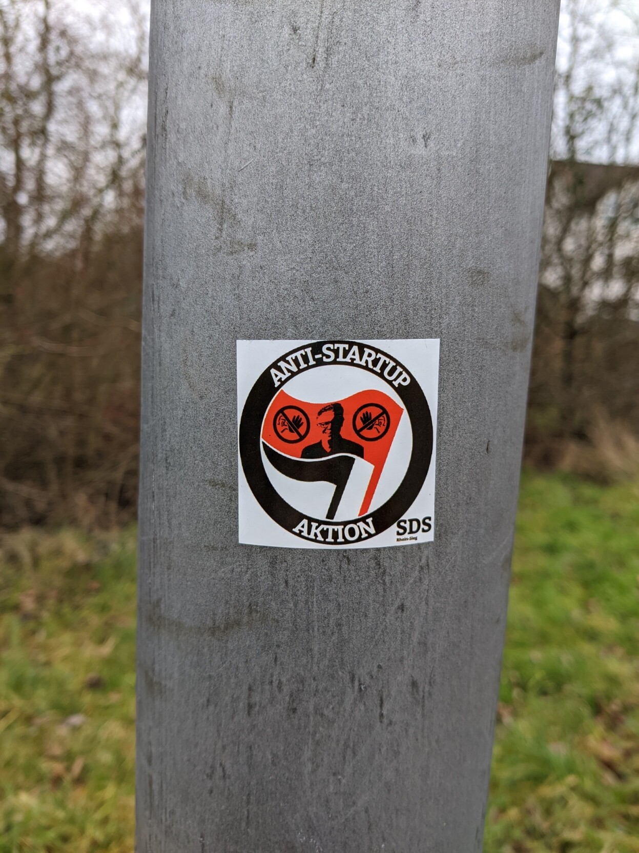 A sticker on a lamp post with the classic Antifa iconography but instead reading 