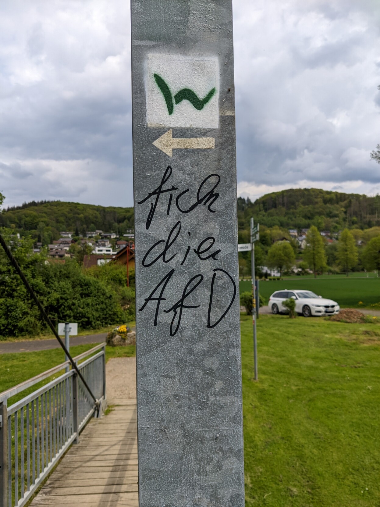 Ein Pfeiler auf einer Fußgängerbrücke mit der Aufschrift 