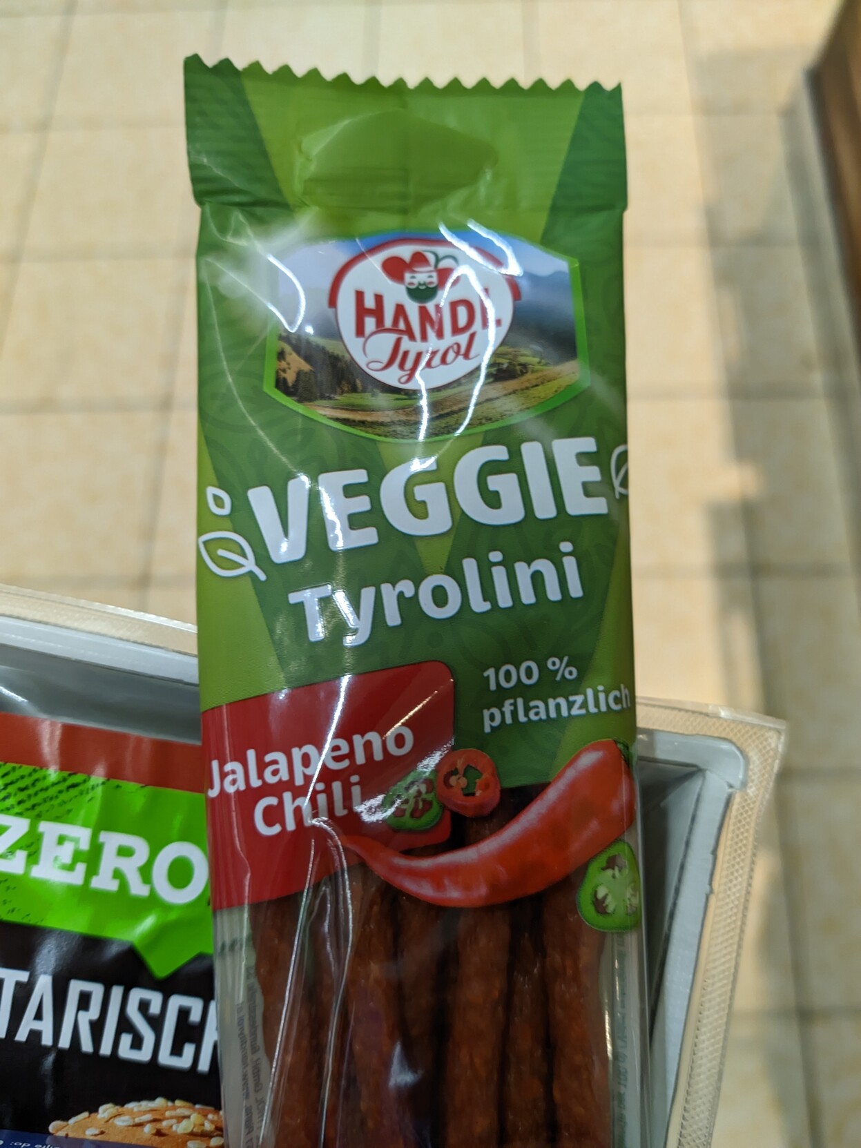 Eine Packung Veggie Tyrolini. Die Verpackung ist grün mit rotem Aufdruck 